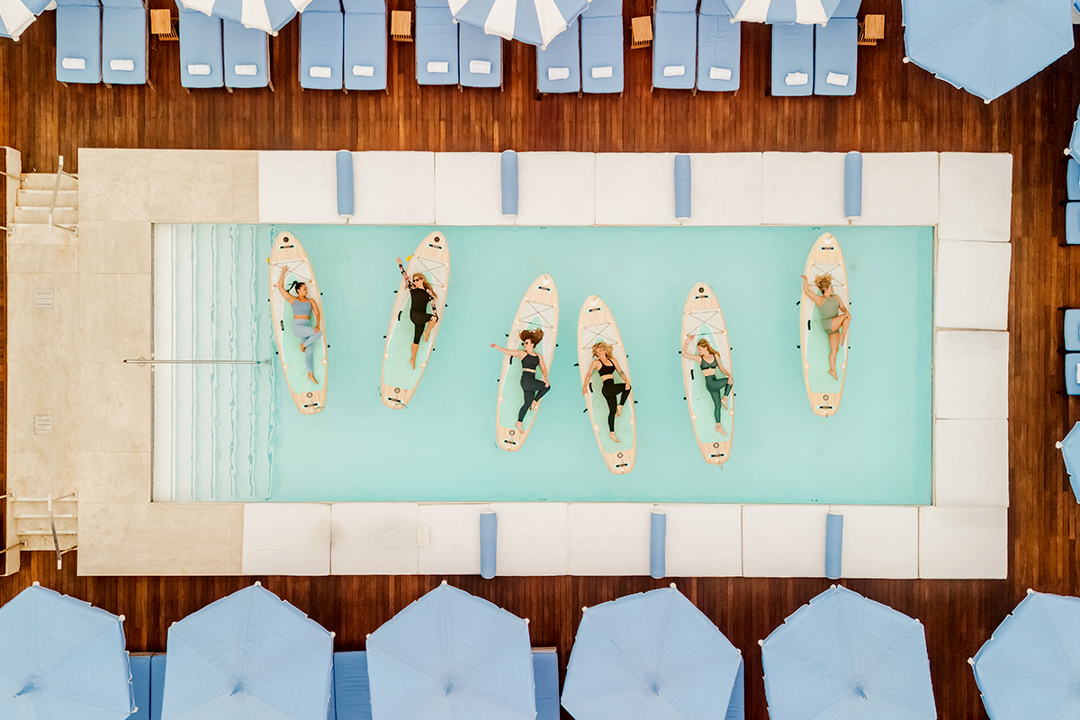 Guests participating in a YOGAqua stand-up paddleboard (SUP) yoga class at The Mayborne.
