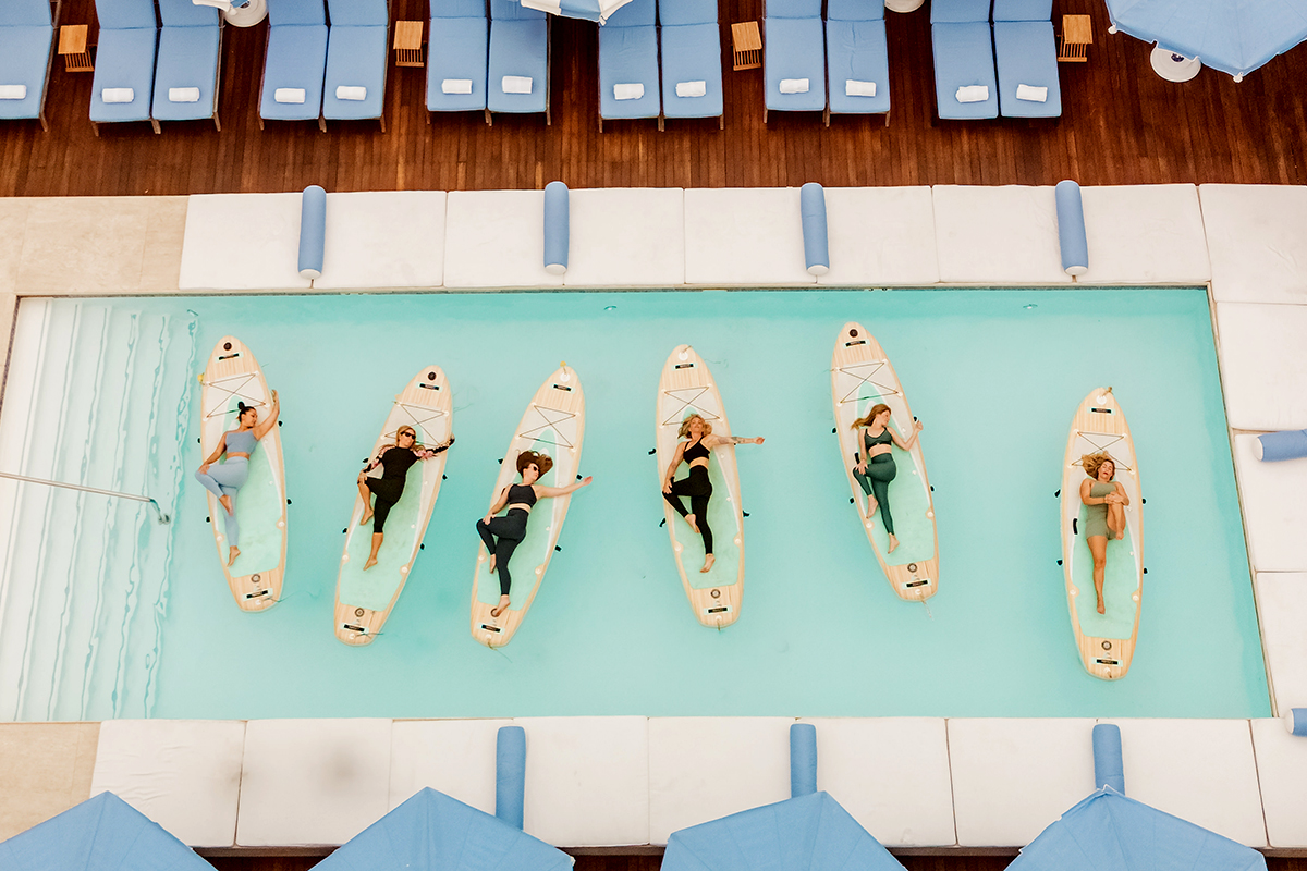 Guests participating in a YOGAqua stand-up paddleboard (SUP) yoga class at The Mayborne.