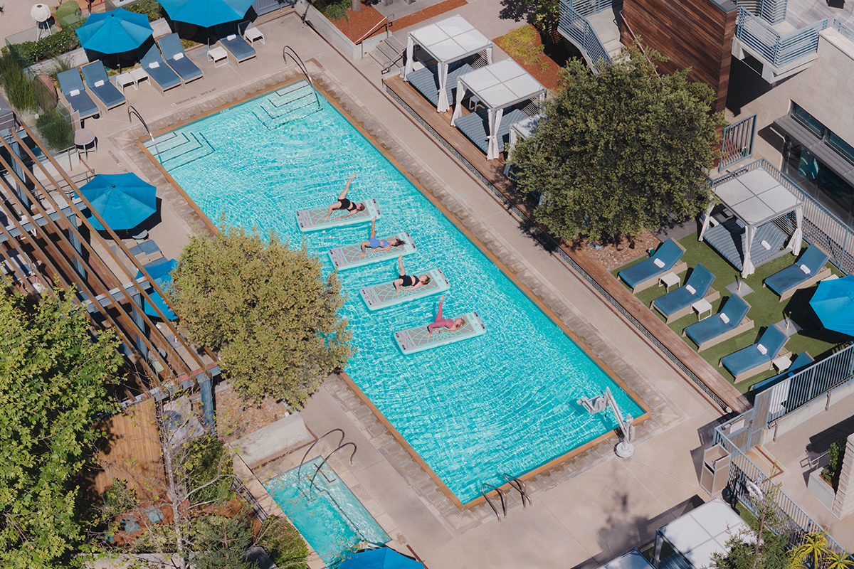 Guests participating in a YOGAqua stand-up paddleboard (SUP) yoga class at Hotel Nia.